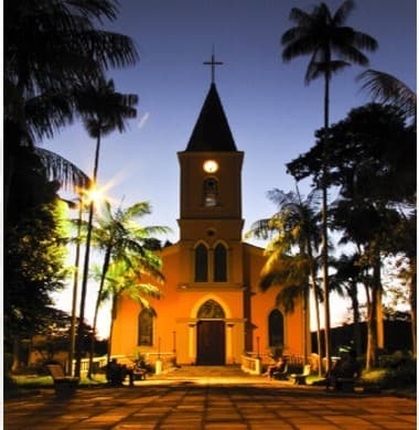 Igreja Matriz de Careaçu ao entardecer, cercada por palmeiras — cartão-postal da cidade